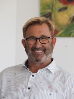 Hausmeisterservice Bauer Team - Mann mit schwarzer Brille lächelt vor Bild