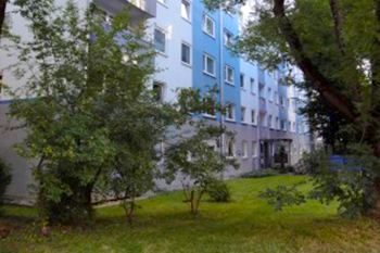 Hausmeisterservice Bauer Referenzen München - Blaue Häuserfront mit grünen Bäumen davor in München