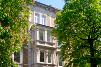 Hausmeisterservice Bauer Referenzen Augsburg - Haus mit Erker hinter zwei grünen Bäumen in Augsburg